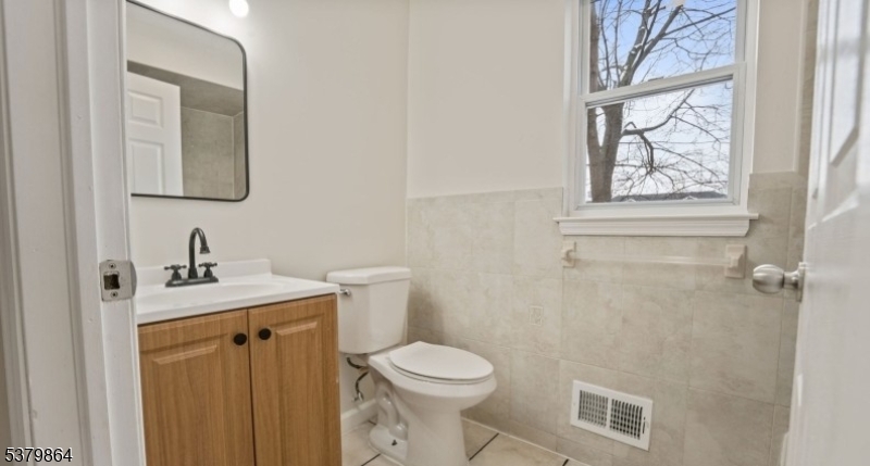 695 South 11th Street Newark, NJ 07103 - Photo 13 of 13 a bathroom with a toilet a sink a mirror and a window