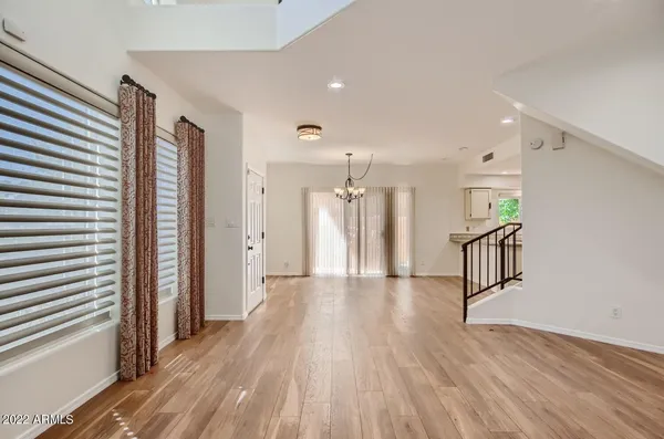a view of a hallway with wooden floor and windows