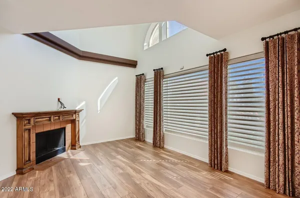 a view of an empty room with a fireplace and a window