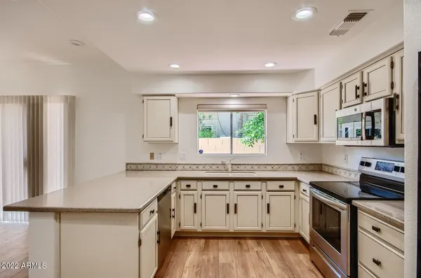 a kitchen with a sink stove cabinets and refrigerator