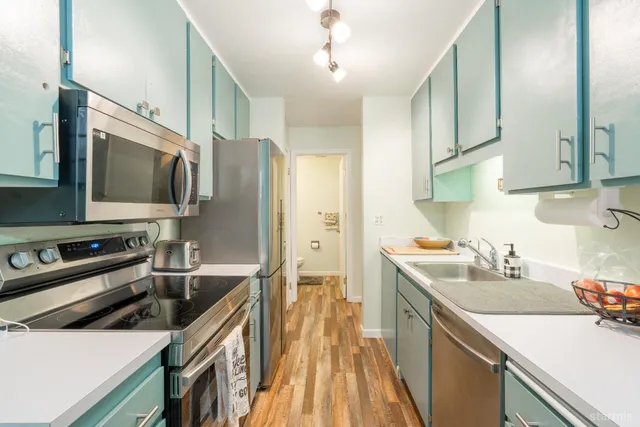a kitchen with stainless steel appliances a sink stove and refrigerator