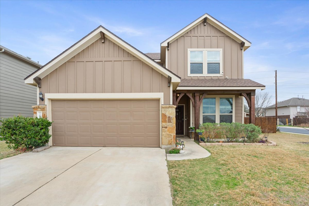 Craftsman inspired home featuring board and batten siding, a front yard, a garage, and a new shingled roof