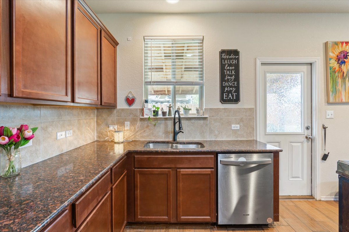 1500 Cliffbrake Way Georgetown, TX 78626 - Photo 12 of 35 Kitchen featuring stainless dishwasher, granite countertops, and a light backsplash