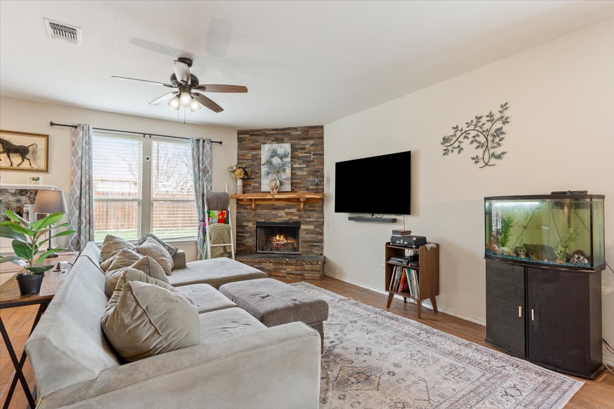 1500 Cliffbrake Way Georgetown, TX 78626 - Photo 8 of 35 Living room featuring a ceiling fan, and a custom stone fireplace