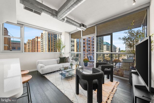 a living room with furniture a large window and a flat screen tv