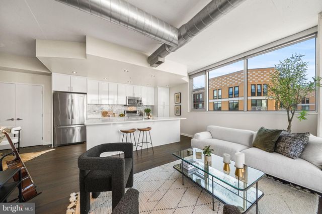 a living room with stainless steel appliances furniture and a large window