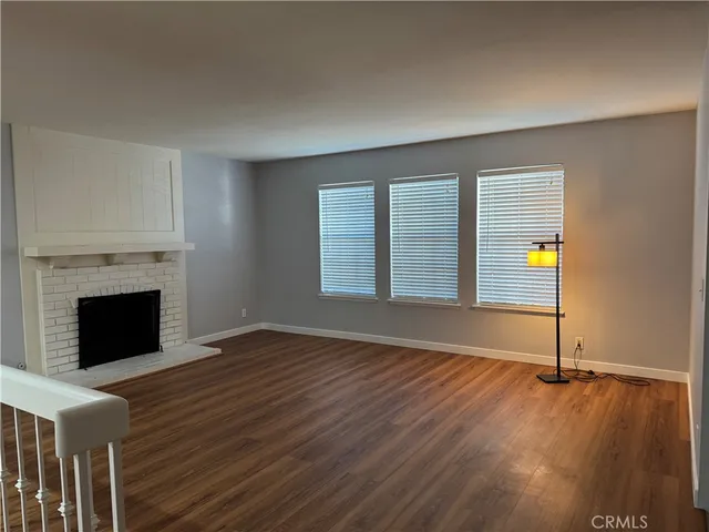 an empty room with wooden floor and fireplace
