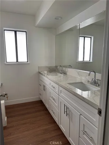 a bathroom with a granite countertop sink and a window