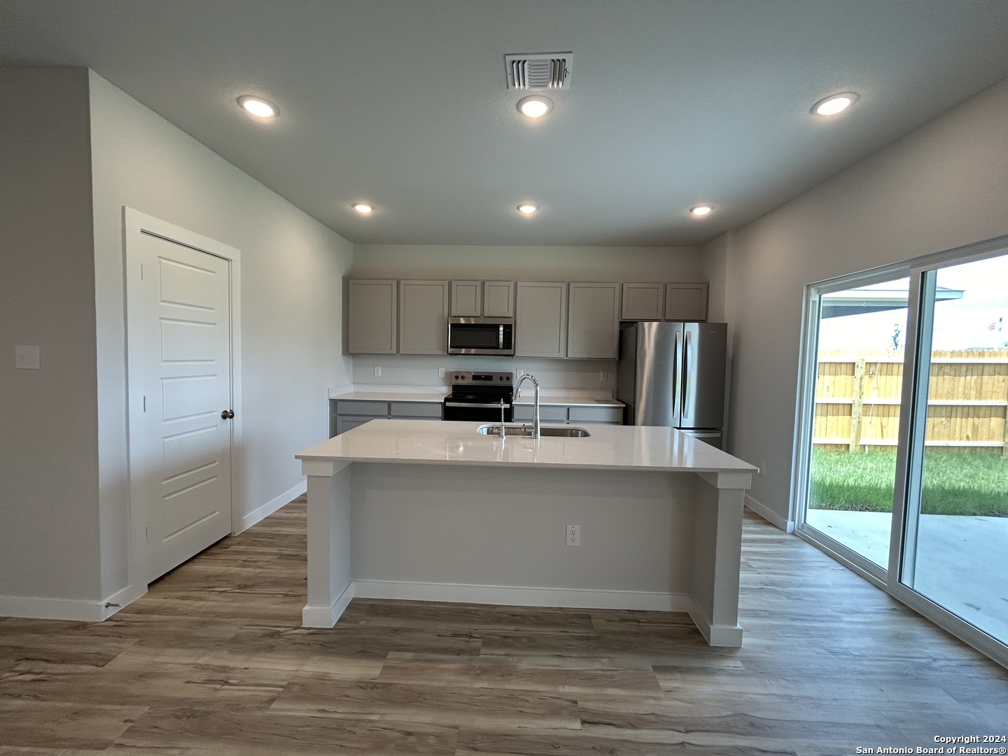 4305 Danforth Street New Braunfels, TX 78130 - Photo 5 of 31 a view of kitchen with stainless steel appliances granite countertop a stove top oven a sink dishwasher a refrigerator and white cabinets with wooden floor