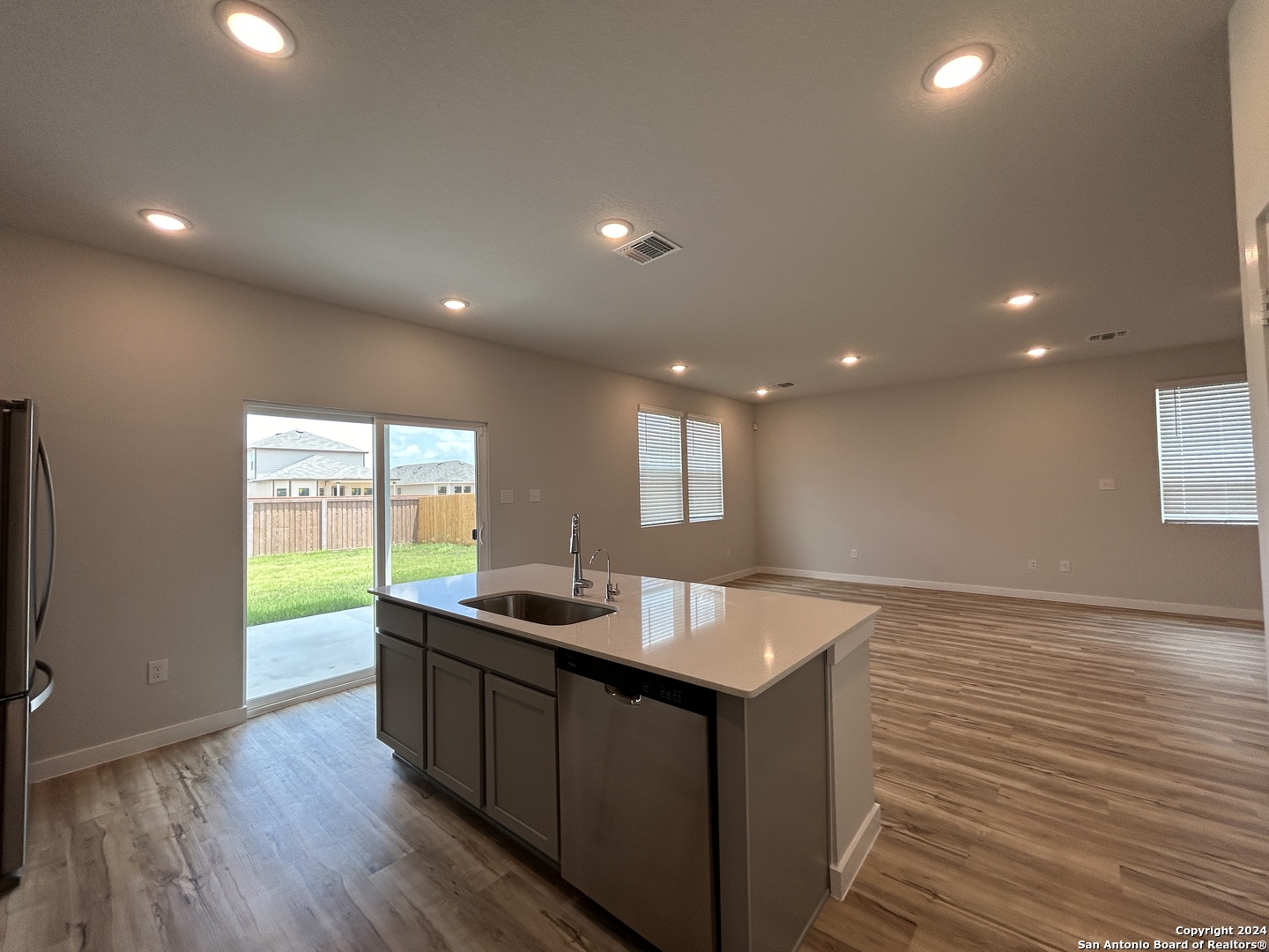 4305 Danforth Street New Braunfels, TX 78130 - Photo 9 of 31 a kitchen with kitchen island a sink wooden floor and a counter top space