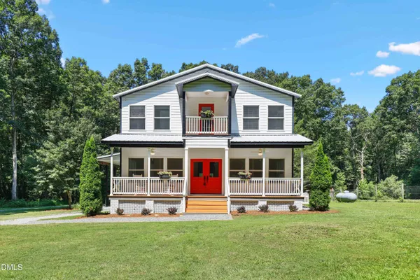 a front view of a house with a garden and yard