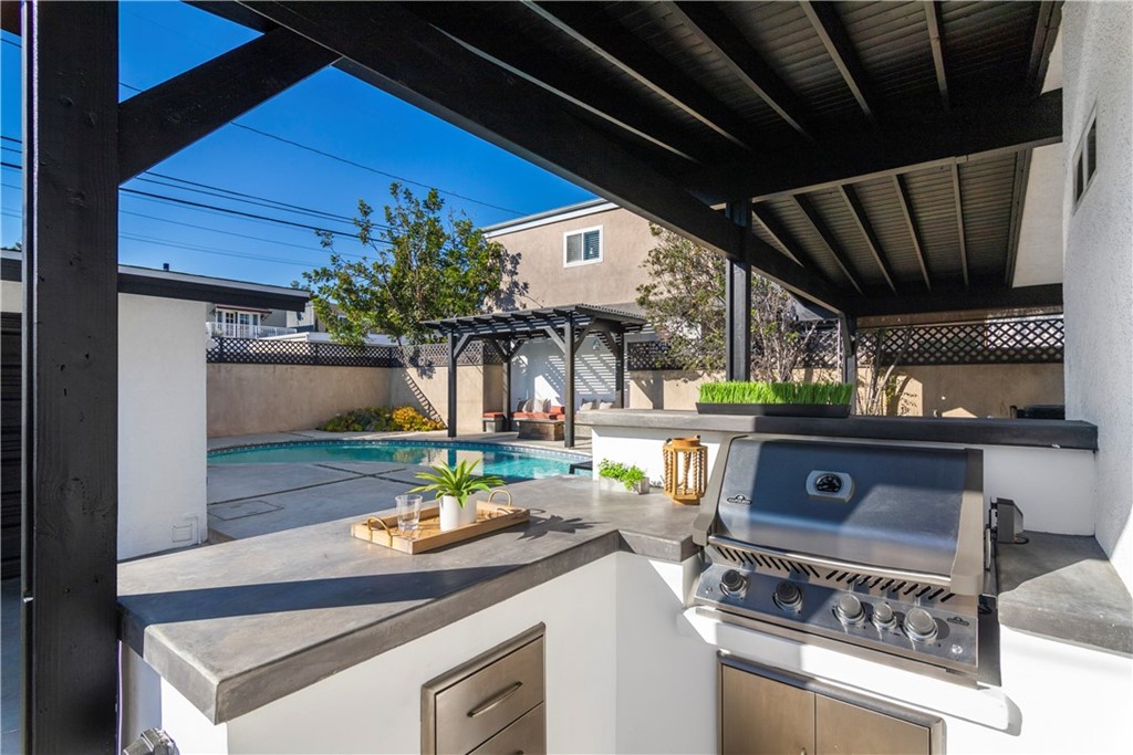 377 Flint Avenue Long Beach, CA 90814 - Photo 36 of 41 a open kitchen with stainless steel appliances granite countertop a sink a stove and a wooden cabinets