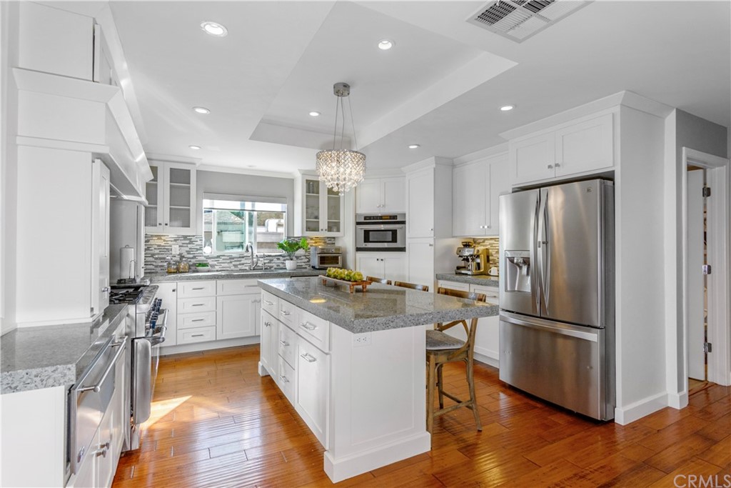 377 Flint Avenue Long Beach, CA 90814 - Photo 7 of 41 a kitchen with a refrigerator a sink and a stove top oven