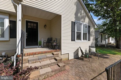a view of house and yard with trees in the background