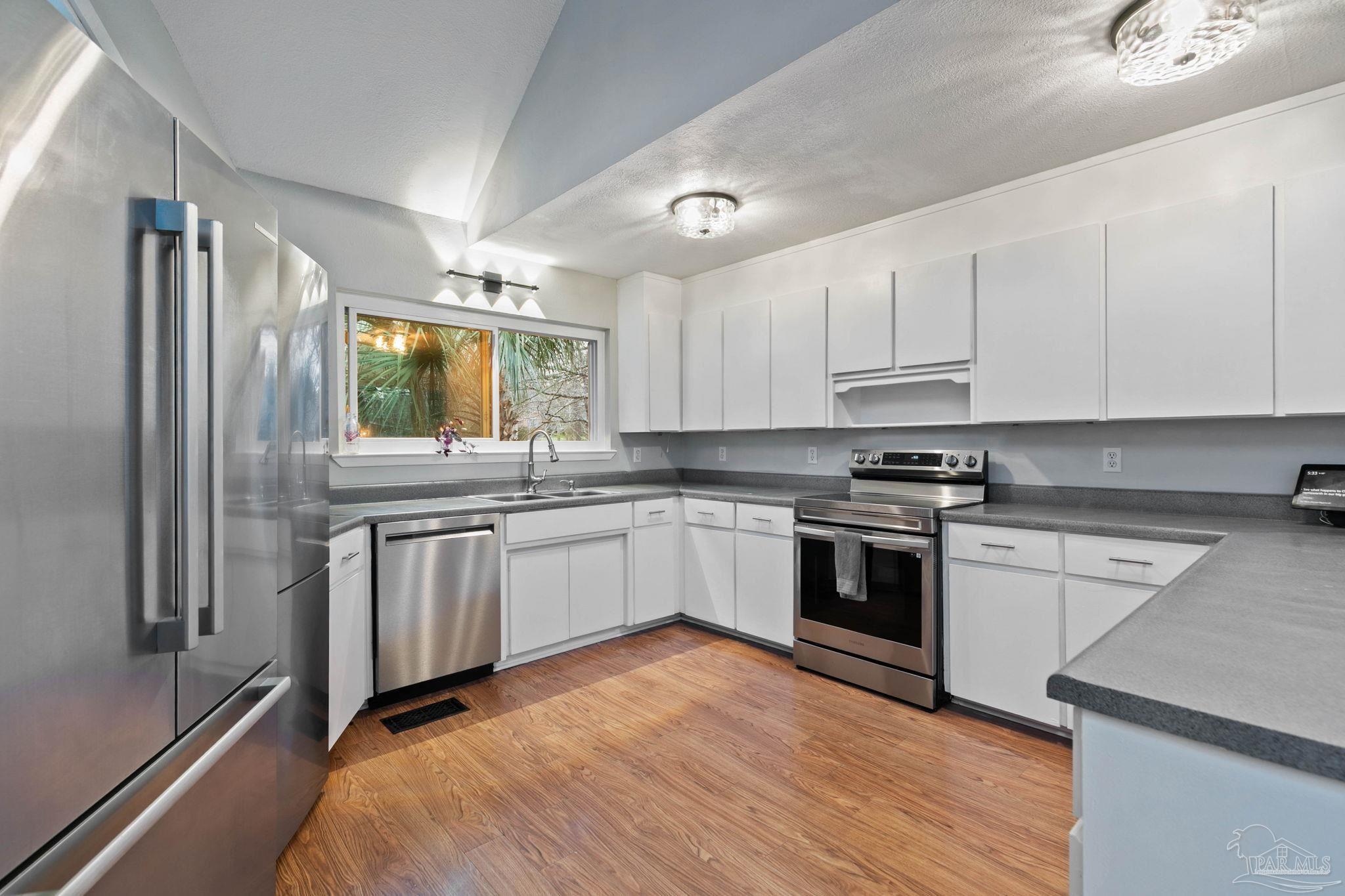 11424 High Springs Road Pensacola, FL 32534 - Photo 11 of 46 a kitchen with stainless steel appliances granite countertop a stove a sink and a refrigerator
