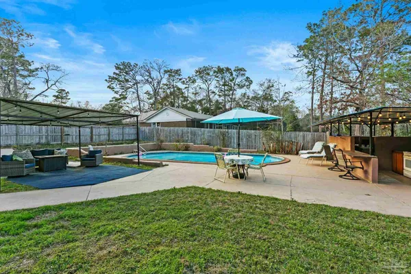 a view of a swimming pool with a patio and a yard