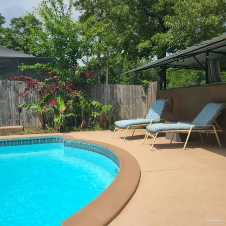 a view of a backyard with swimming pool