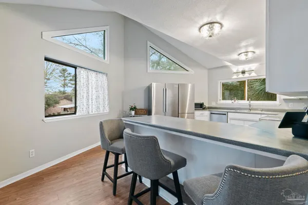 a kitchen with stainless steel appliances granite countertop a table chairs and a refrigerator