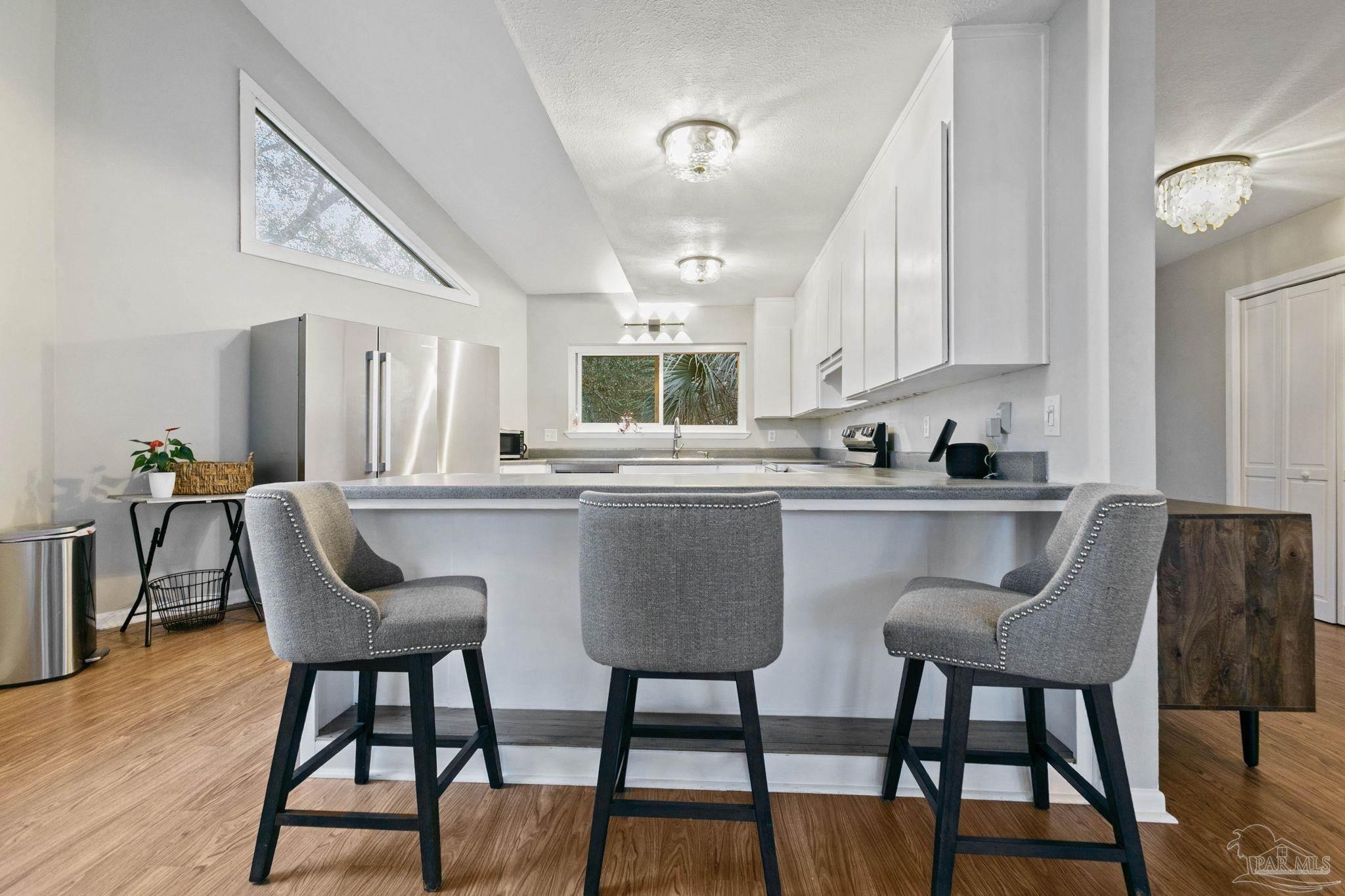 11424 High Springs Road Pensacola, FL 32534 - Photo 10 of 46 a kitchen with stainless steel appliances granite countertop a table chairs and a refrigerator