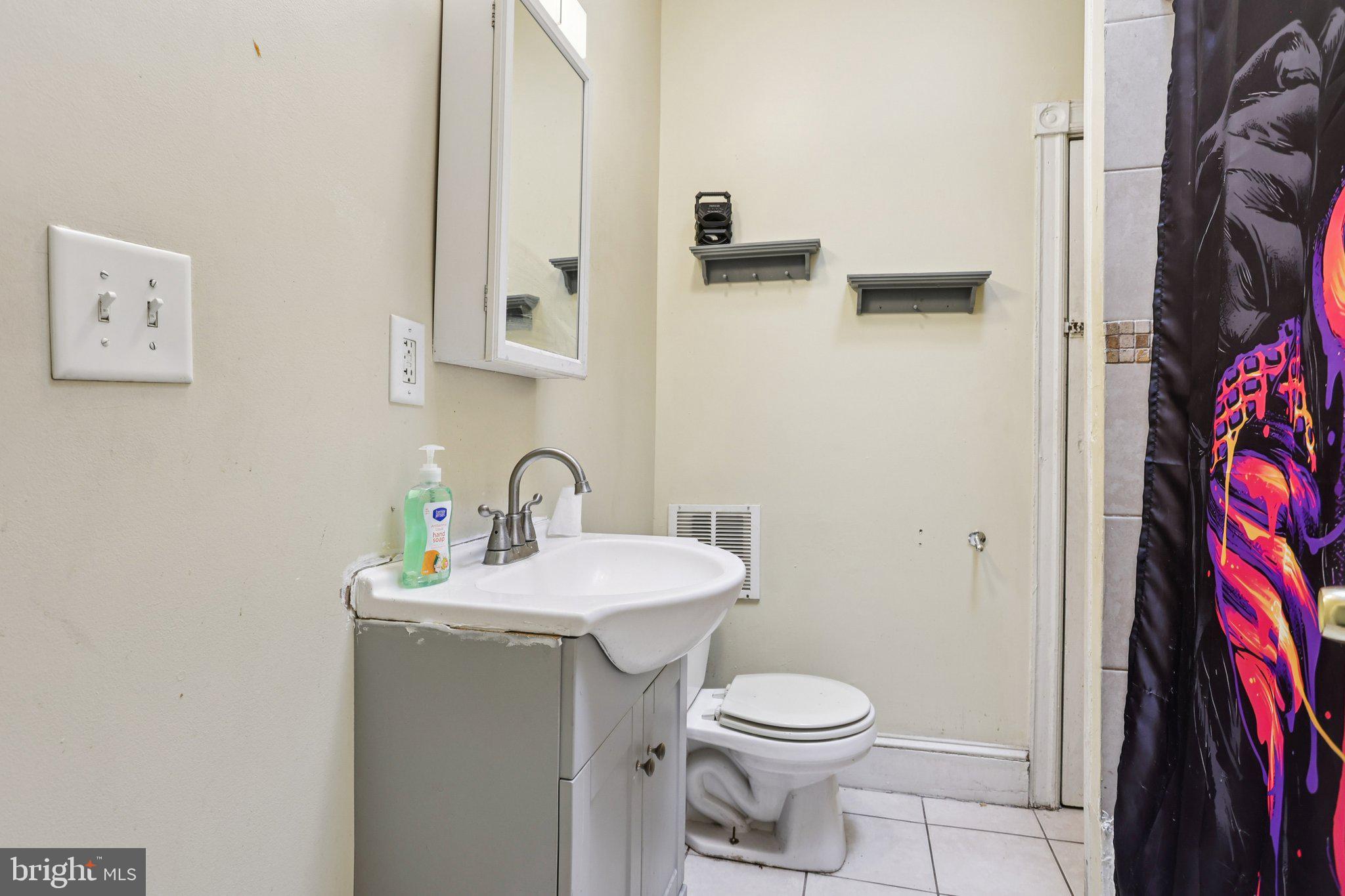 115 North Peach Street Philadelphia, PA 19139 - Photo 18 of 19 a bathroom with a toilet sink and mirror