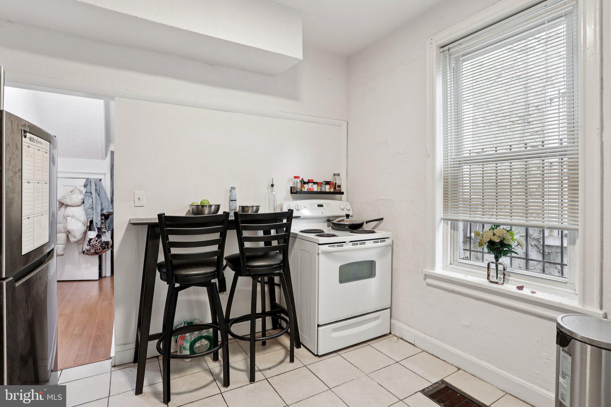 115 North Peach Street Philadelphia, PA 19139 - Photo 6 of 19 a kitchen with a stove and chairs