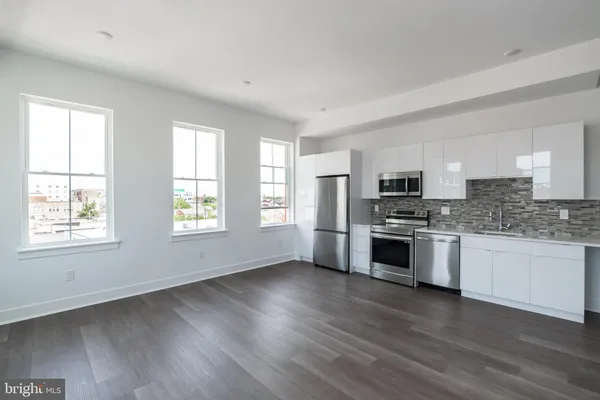 a kitchen with granite countertop white cabinets and stainless steel appliances