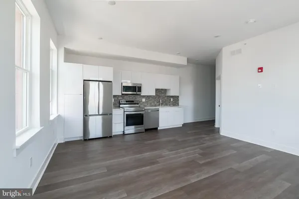 a kitchen with stainless steel appliances a refrigerator and a stove top oven
