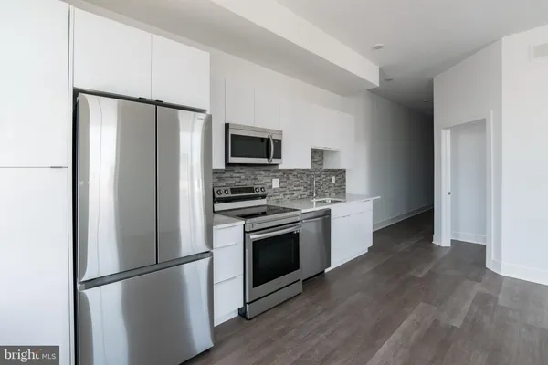 a kitchen with stainless steel appliances a refrigerator stove and microwave