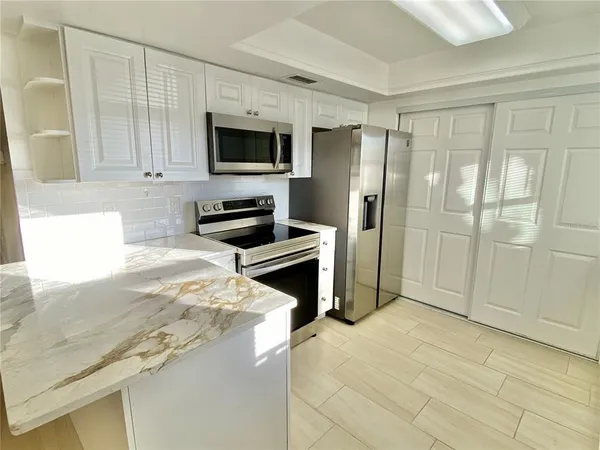 a kitchen with granite countertop a refrigerator and a sink