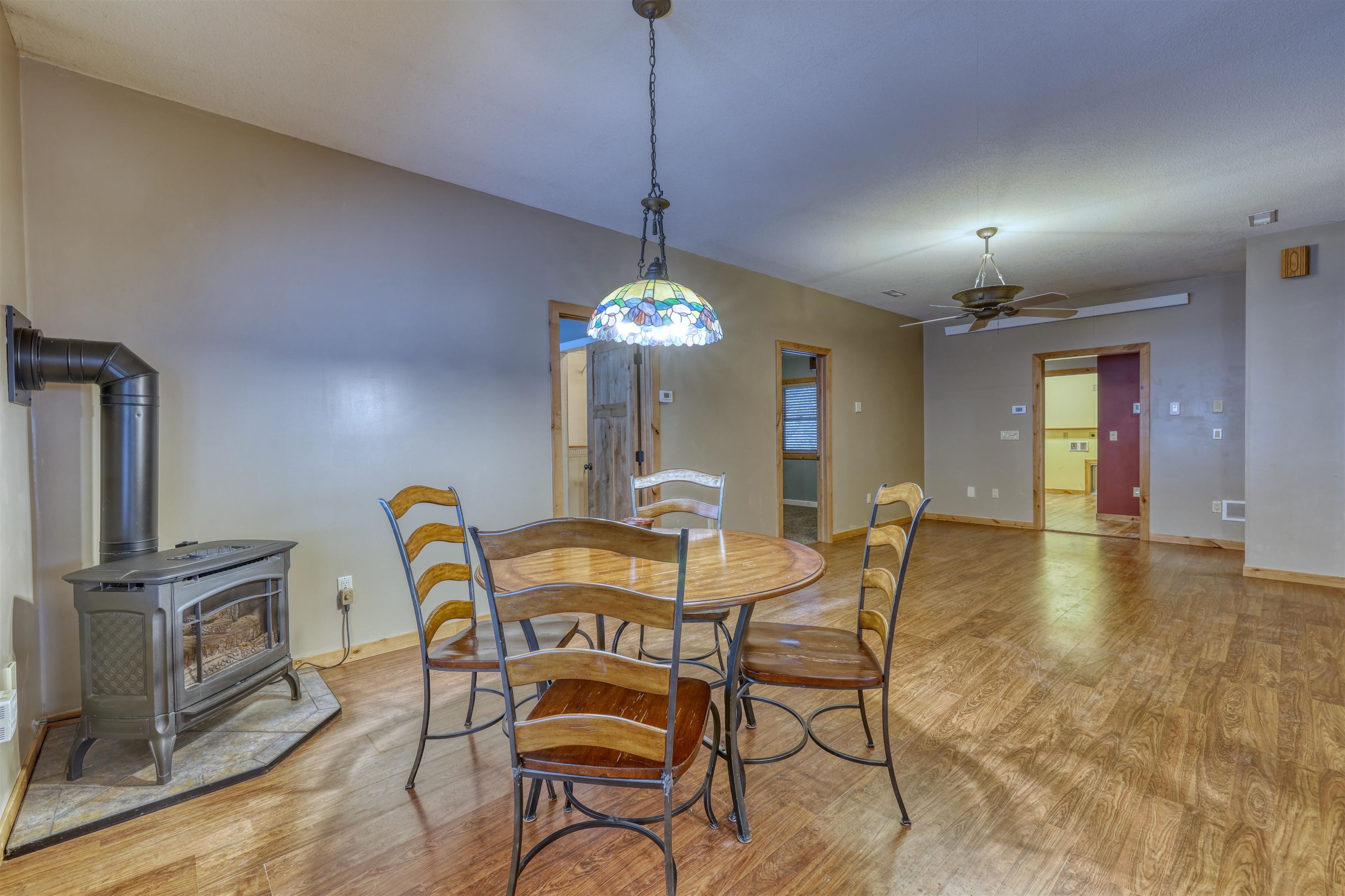 15531 West Hospital Road Hayward, WI 54843 - Photo 26 of 71 Dining room featuring a wood stove, light wood-type flooring, and ceiling fan