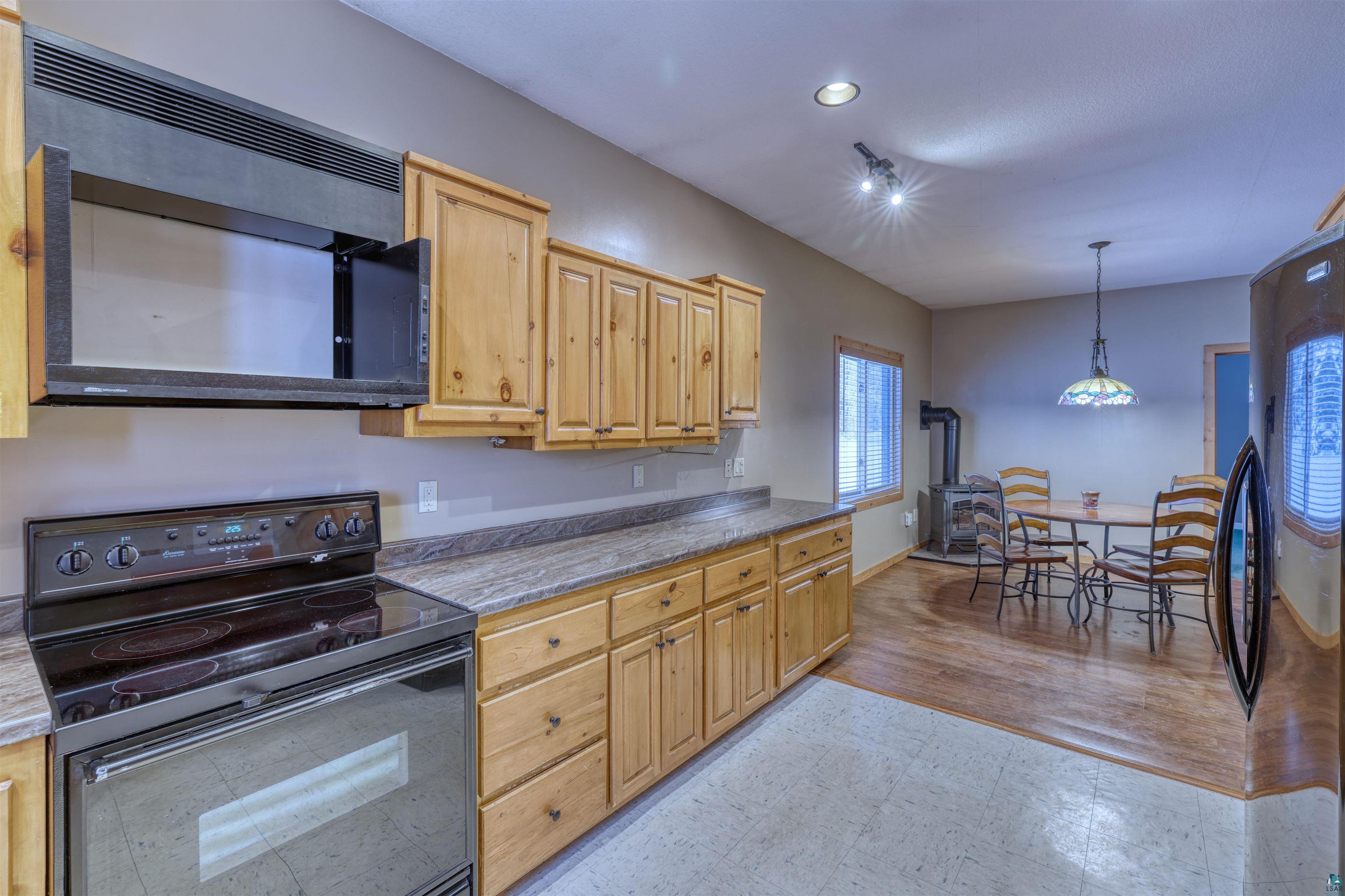 15531 West Hospital Road Hayward, WI 54843 - Photo 32 of 71 Kitchen with black appliances, light flooring, pendant lighting, recessed lighting, and light countertops
