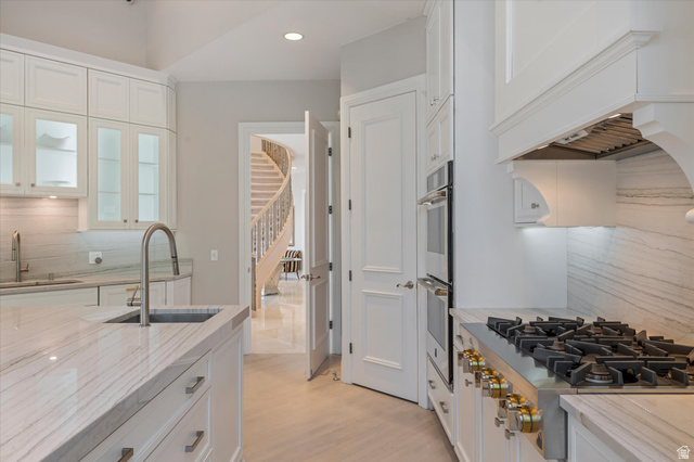 3222 Eagle View Circle Sandy, UT 84092 - Photo 16 of 60 Kitchen featuring decorative backsplash, white cabinets, stainless steel appliances, and recessed lighting