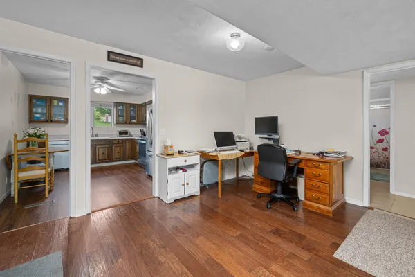 a view of a workspace with furniture and wooden floor