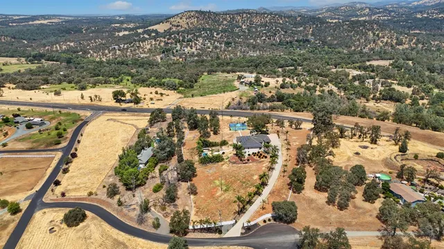 an aerial view of a house with a yard and garden