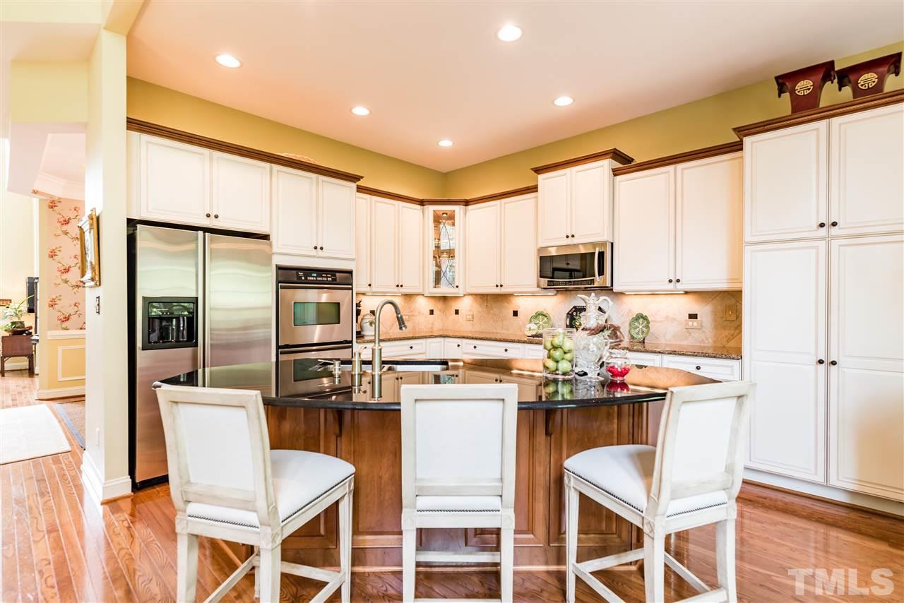 2247 Clayette Court Raleigh, NC 27612 - Photo 11 of 25 a kitchen with kitchen island white cabinets and stainless steel appliances