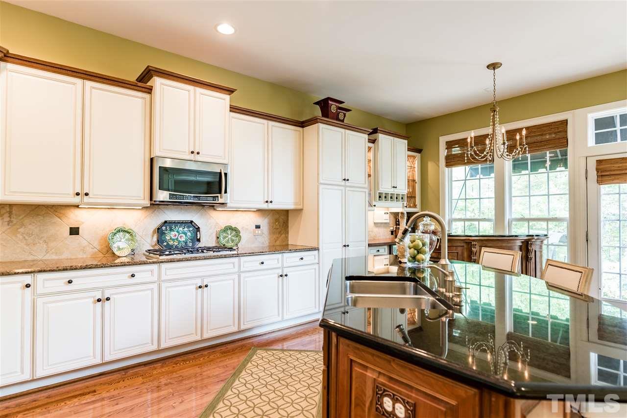 2247 Clayette Court Raleigh, NC 27612 - Photo 14 of 25 a kitchen with stainless steel appliances granite countertop a sink stove and cabinets