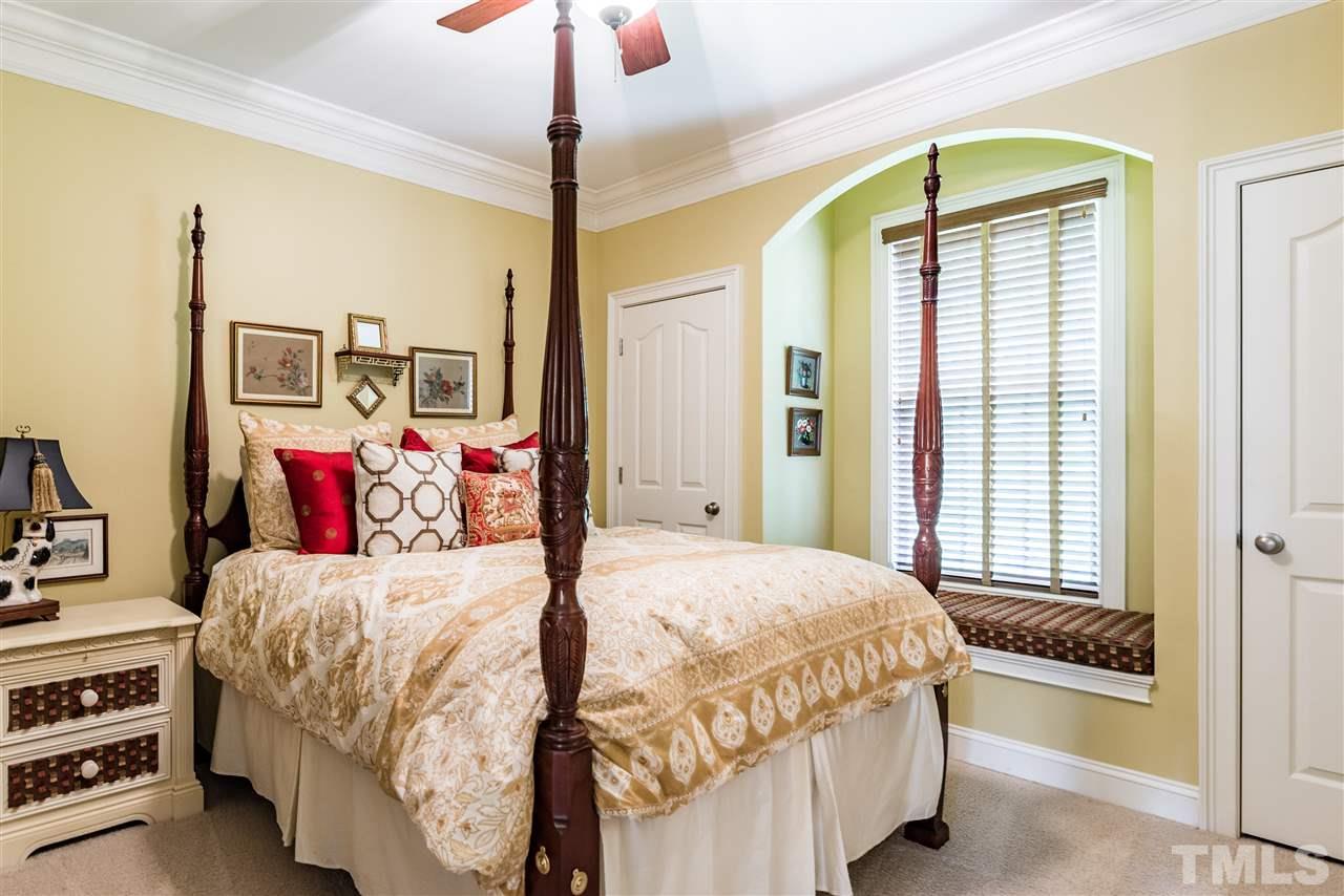 2247 Clayette Court Raleigh, NC 27612 - Photo 20 of 25 a bedroom with a large bed and a chandelier