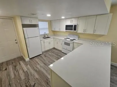a kitchen with a sink a stove top oven and white stainless steel appliances