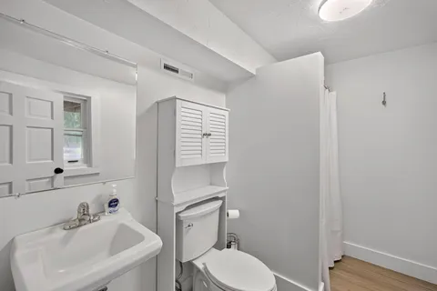 a bathroom with a toilet sink and mirror