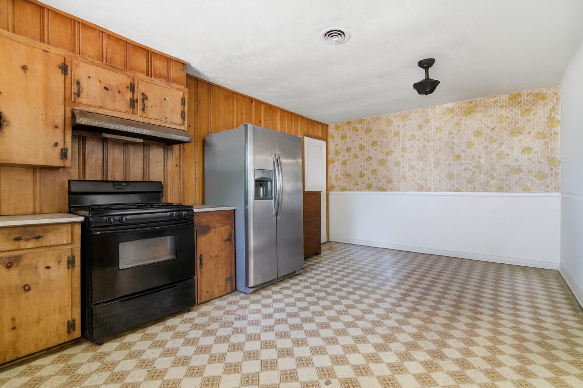 1200 Foster Drive Conroe, TX 77301 - Photo 4 of 18 a kitchen with granite countertop a stove a refrigerator and cabinets