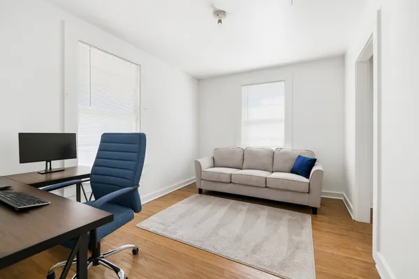a living room with furniture and a wooden floor