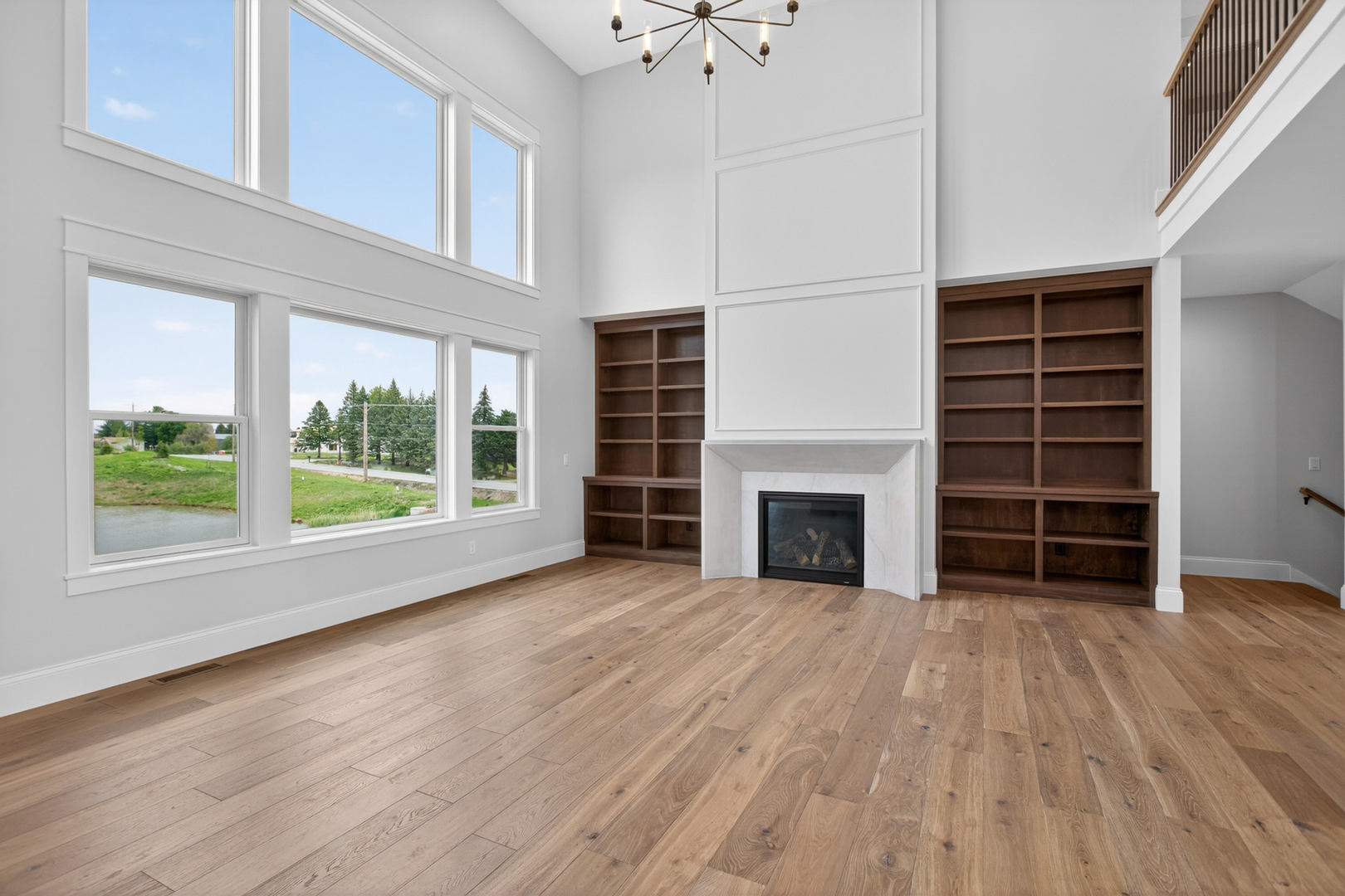 6928 Wilderness Pointe Bettendorf, IA 52722 - Photo 11 of 48 an empty room with wooden floor fireplace and windows