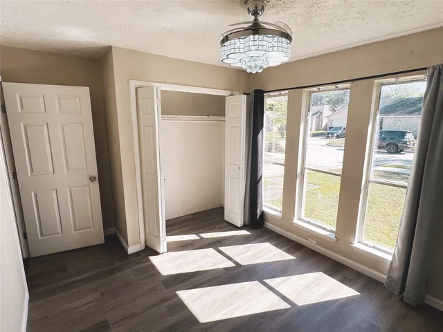 a view of a big room with wooden floor and windows