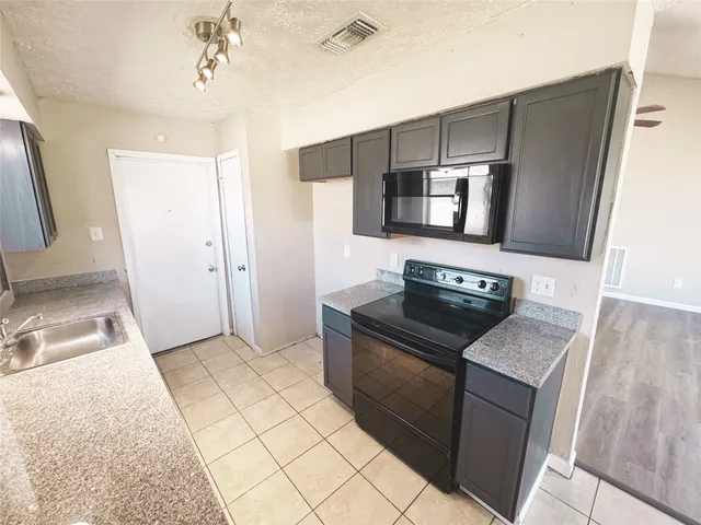 a kitchen with granite countertop a sink and a stove top oven
