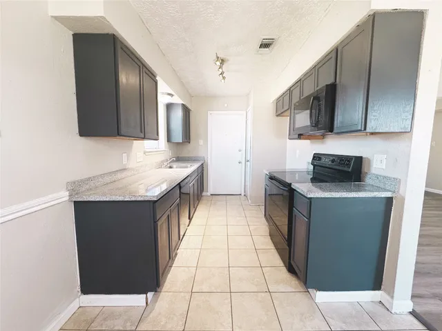 a kitchen with stainless steel appliances granite countertop a sink and a stove top oven