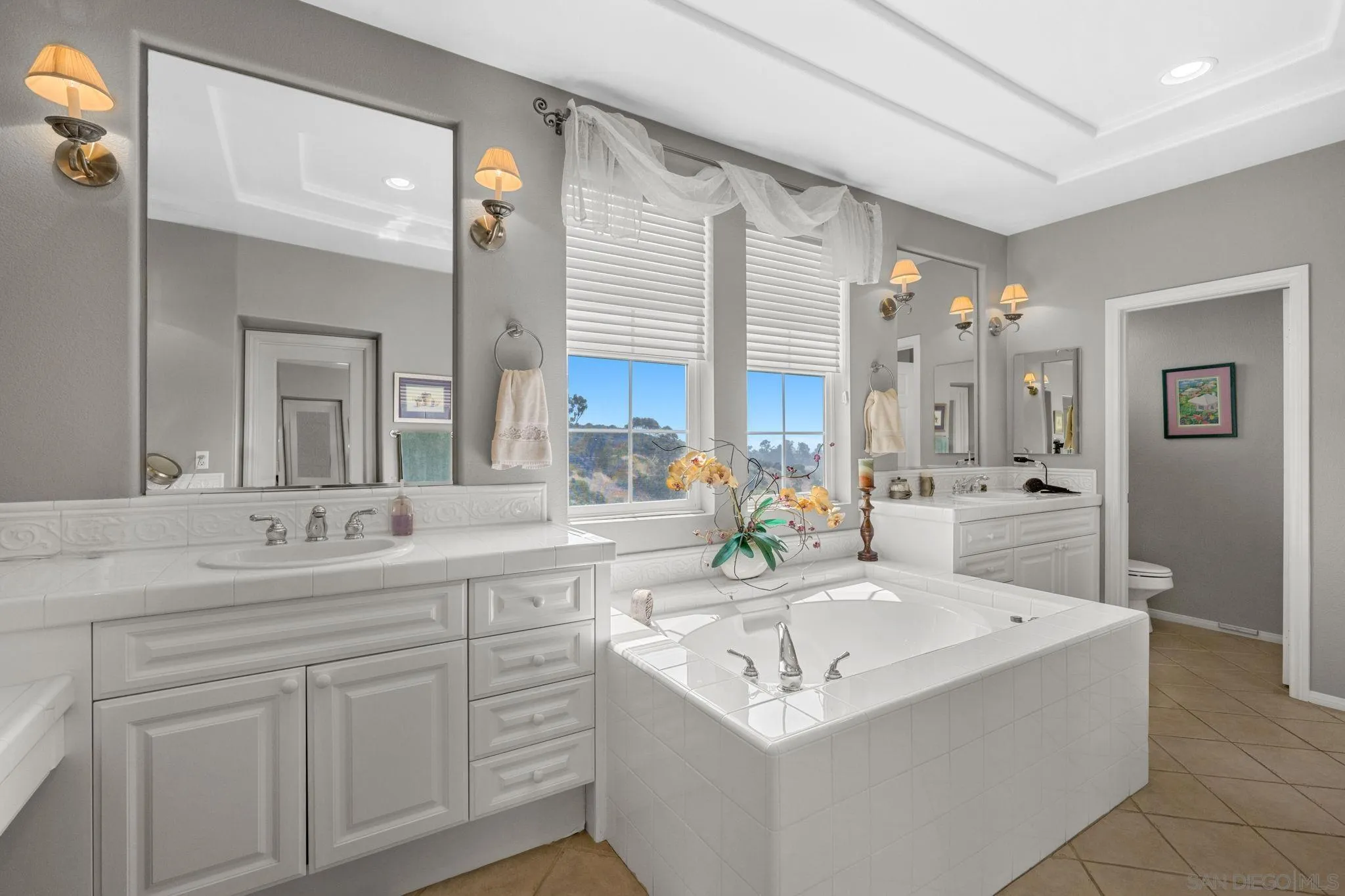 1369 Ranch Road Encinitas, CA 92024 - Photo 23 of 34 a bathroom with a sink vanity granite tub and a mirror