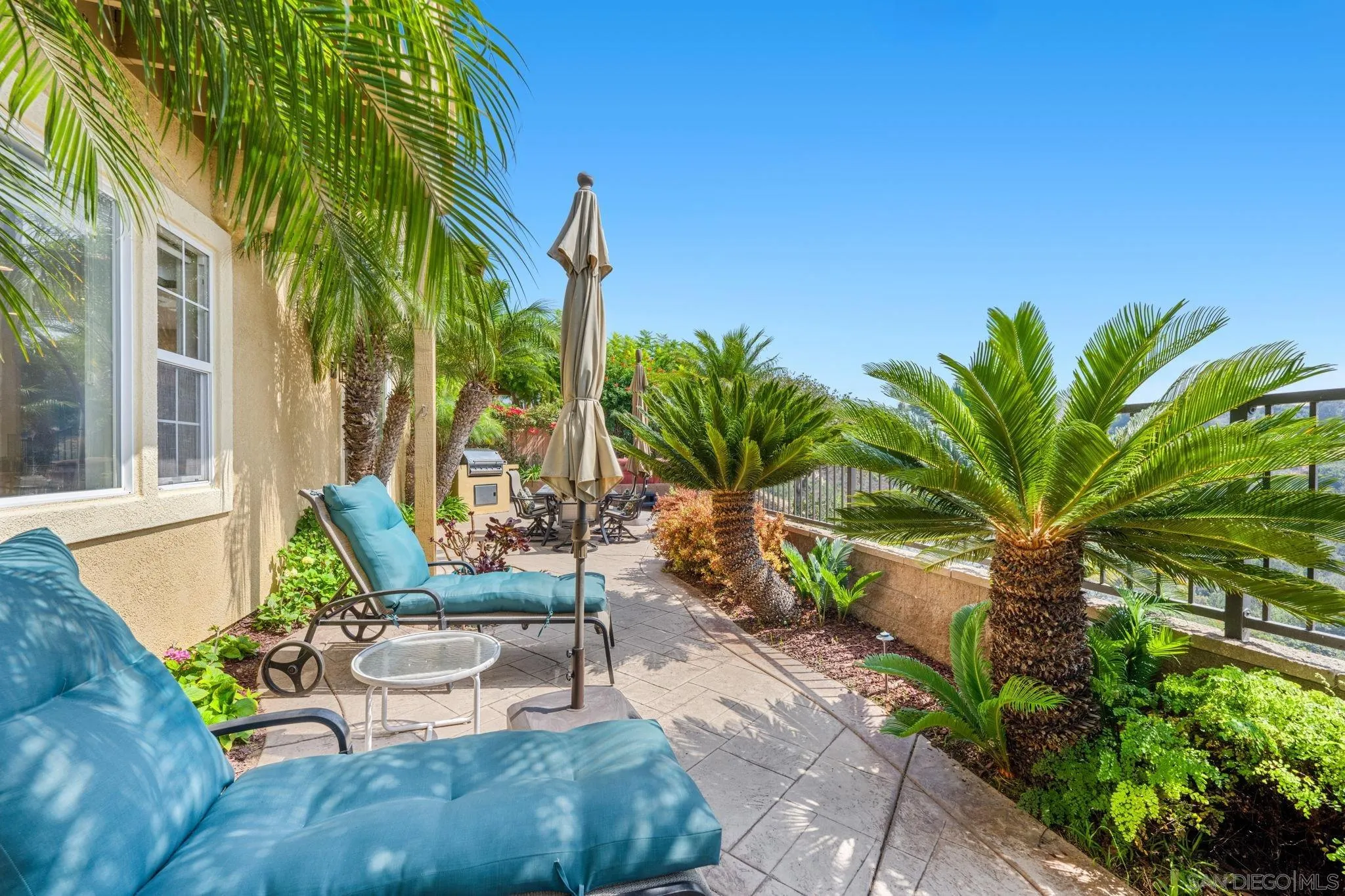 1369 Ranch Road Encinitas, CA 92024 - Photo 31 of 34 a view of a patio with table and chairs potted plants and palm tree