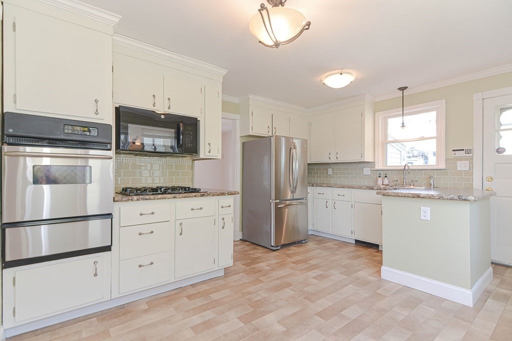 12 Ballard Street Saugus, MA 01906 - Photo 12 of 38 a kitchen with white cabinets and stainless steel appliances