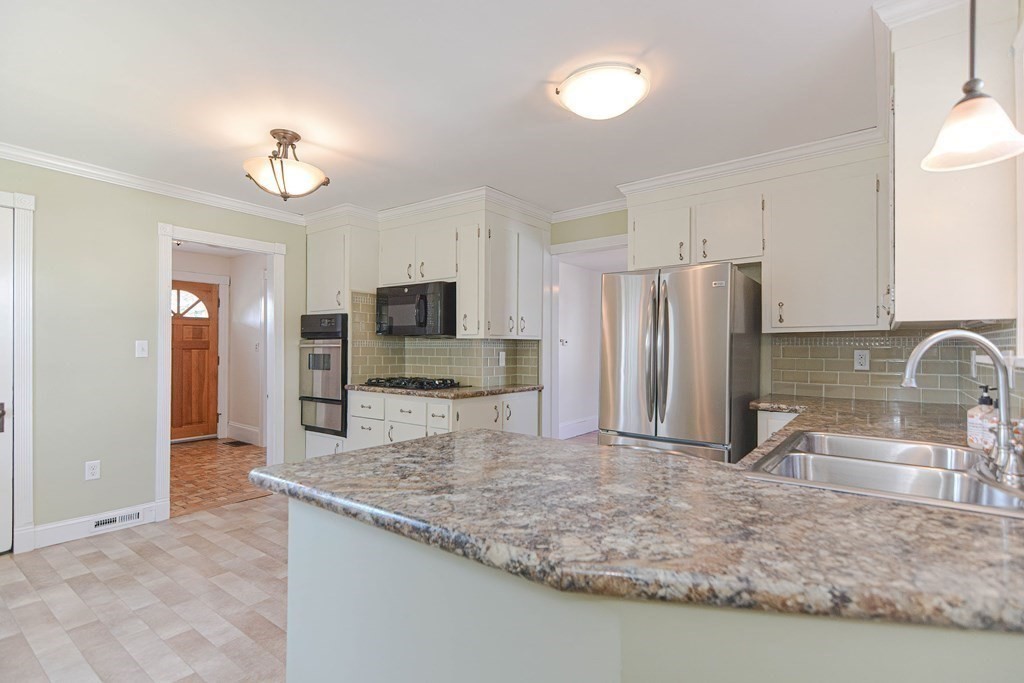 12 Ballard Street Saugus, MA 01906 - Photo 14 of 38 a kitchen with stainless steel appliances granite countertop a sink refrigerator and microwave