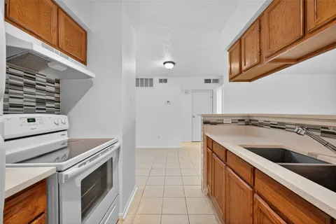 a kitchen with granite countertop a sink and a stove top oven